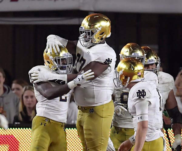 Notre Dame running back Dexter Williams, left, celebrates a touchdown with Micah Dew-Treadway, center, and quarterback Ian Book during the second half