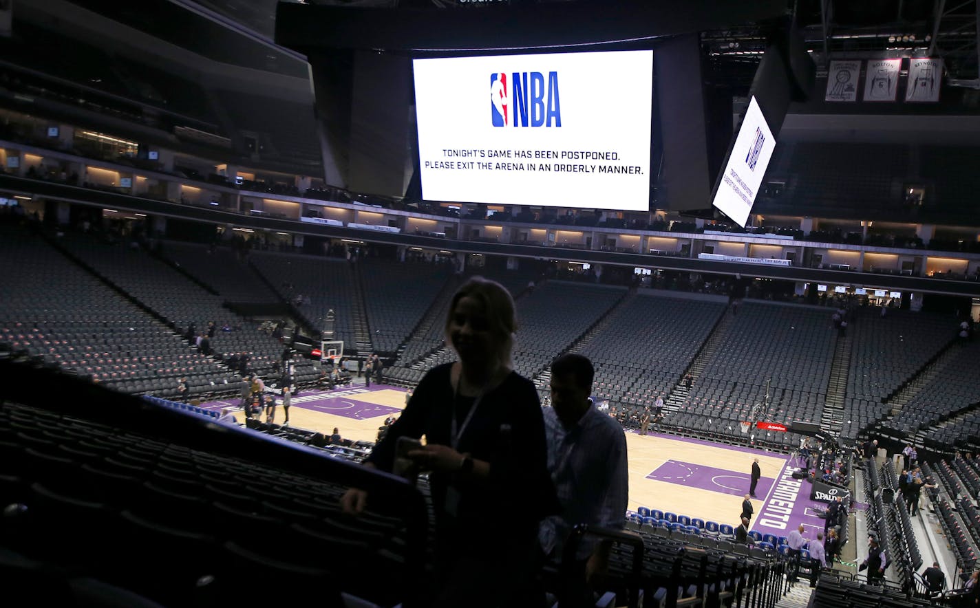 FILE - In this March 11, 2020 photo, fans leave the Golden 1 Center in Sacramento, Calif., after the NBA basketball game between the New Orleans Pelicans and Sacramento Kings was postponed at the last minute over an "abundance of caution" after a player for the Jazz tested positive for the coronavirus. A person with knowledge of the situation says NBA players will be allowed to return to team training facilities starting Friday, May 1 provided that their local governments do not have a stay-at-home order prohibiting such movement. (AP Photo/Rich Pedroncelli, File)