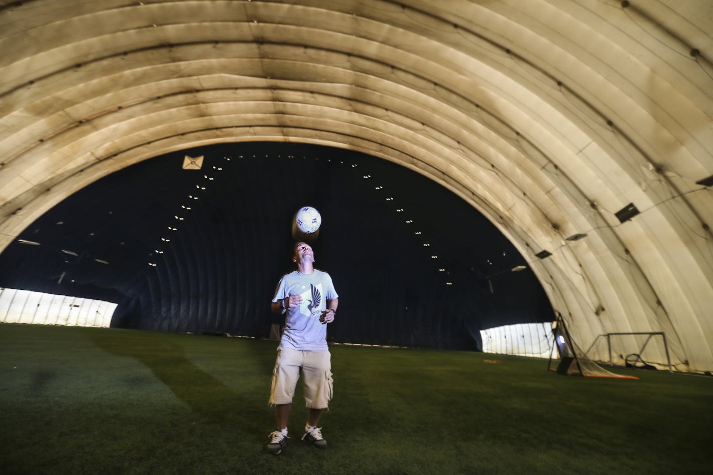 Donny Mark owns the 10 Sports Centre with his dad. It used to be a golf dome and is now in transition to become a soccer and multi-sports facility. He did a header for a picture with the navy background of the dome that was dark so golfers could see the white balls on Friday, August 1, 2014, in Long Lake, Minn. ] RENEE JONES SCHNEIDER &#x2022; reneejones@startribune.com