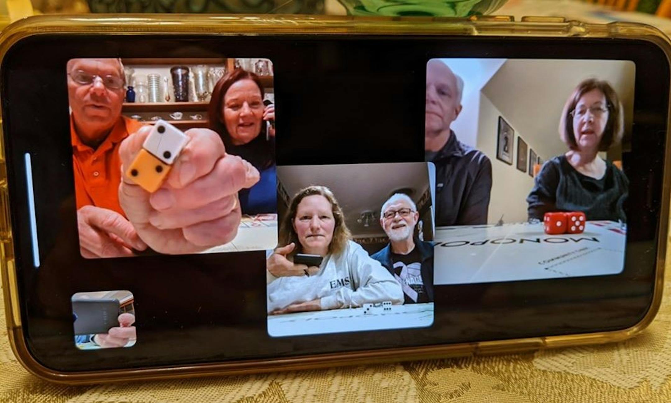 James Schlafer and his wife, Diana, show their roll of double two's to Carol Jackson and her husband, Ron Liebelt, (middle) and Paul Schlafer and his wife Dianne (right with red dice) during a recent family game of Monopoly over Facebook Messenger.