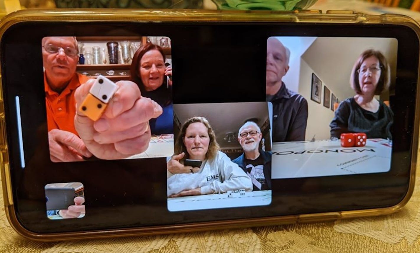 James Schlafer and his wife, Diana, show their roll of double two's to Carol Jackson and her husband, Ron Liebelt, (middle) and Paul Schlafer and his wife Dianne (right with red dice) during a recent family game of Monopoly over Facebook Messenger.