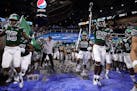 Coach Chris Creighton, middle left, led his Eastern Michigan team onto the field against Pittsburgh in the 2019 Quick Lane Bowl at Ford Field in Detro