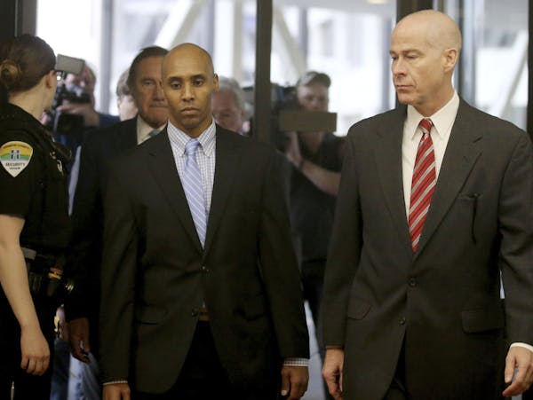 Former Minneapolis police officer Mohamed Noor walks through the skyway with his attorney Thomas Plunkett, right, on the way to court for the verdict 