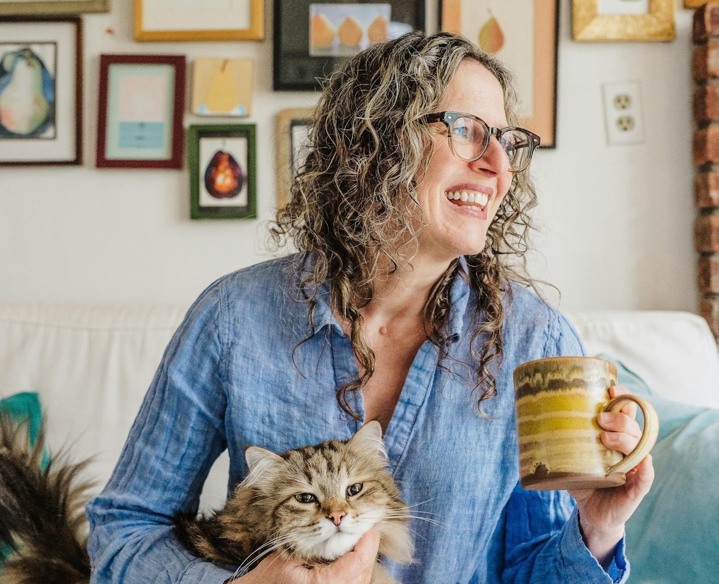 photo of author Catherine Newman, holding a mug and a cat