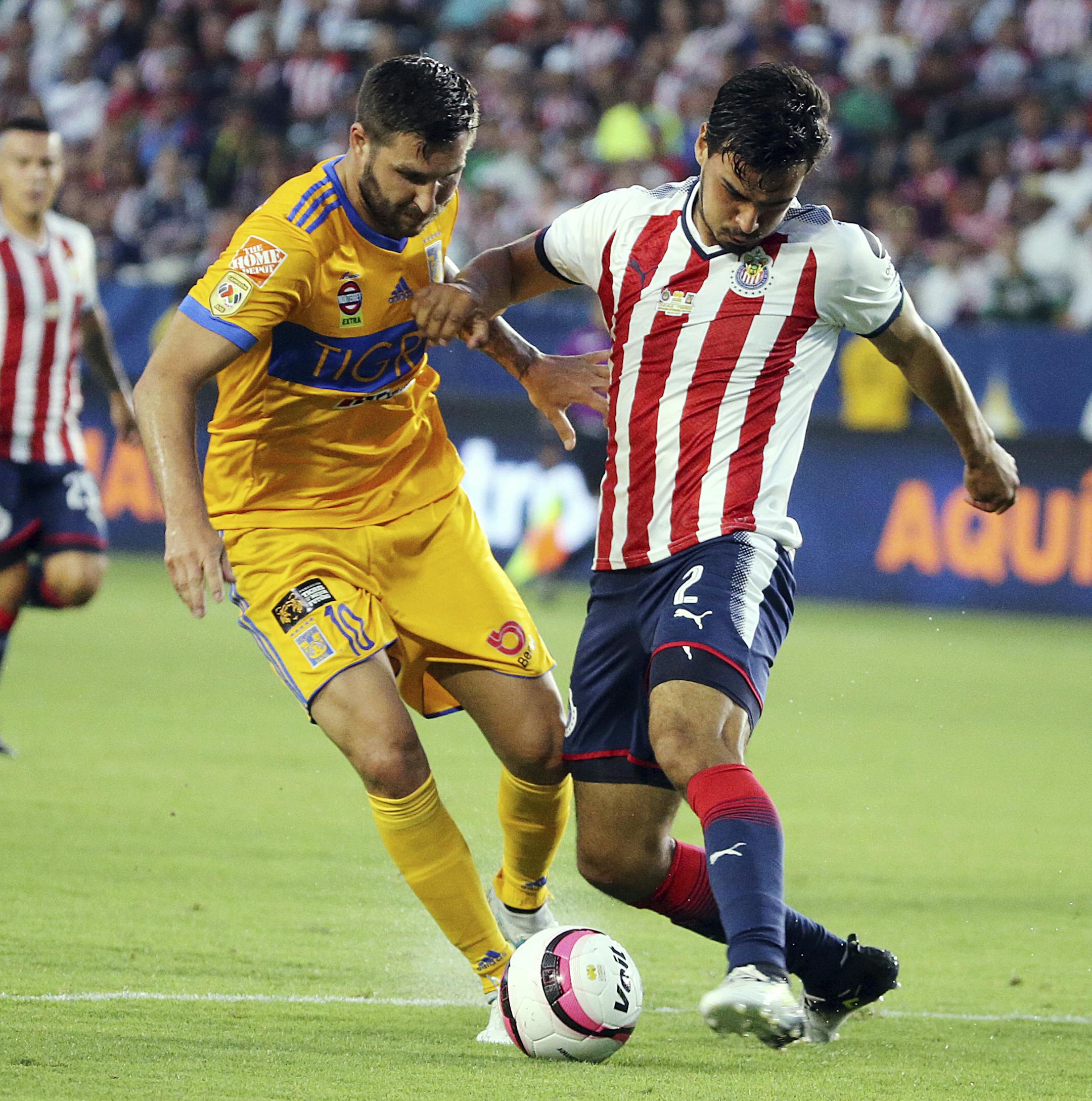 Tigre UANL orward Andre-Pierre Gignac (10), left, and Chivas de Guadalajara defender Oswaldo Alanis (2) battle in the first half of a Champion of Champions (Campeon de Campeones) soccer match in Carson, Calif., Sunday, July 16, 2017. (AP Photo/Reed Saxon)