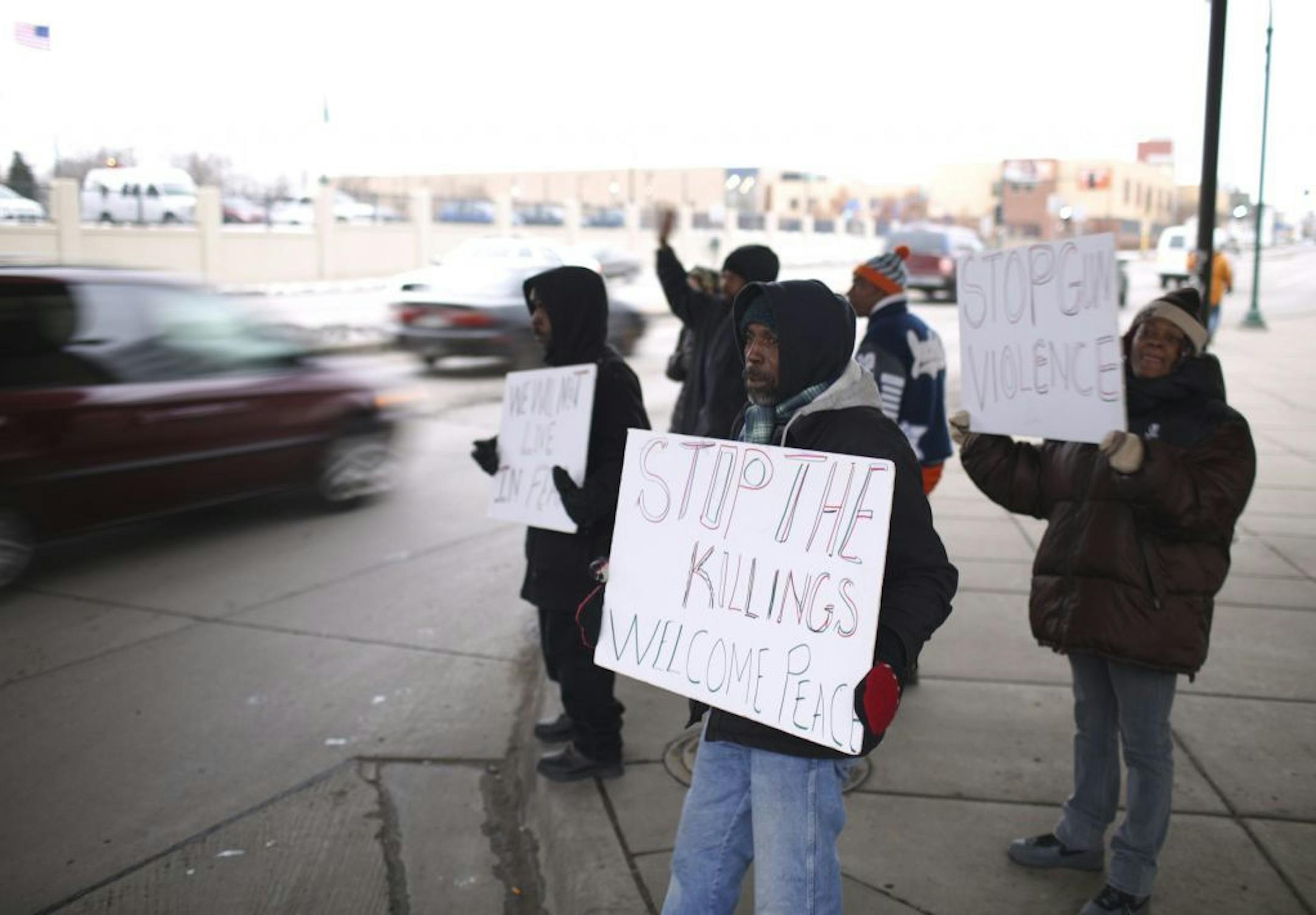 A small group of demonstrators held signs beneath the Lake St. LRT station Monday afternoon.