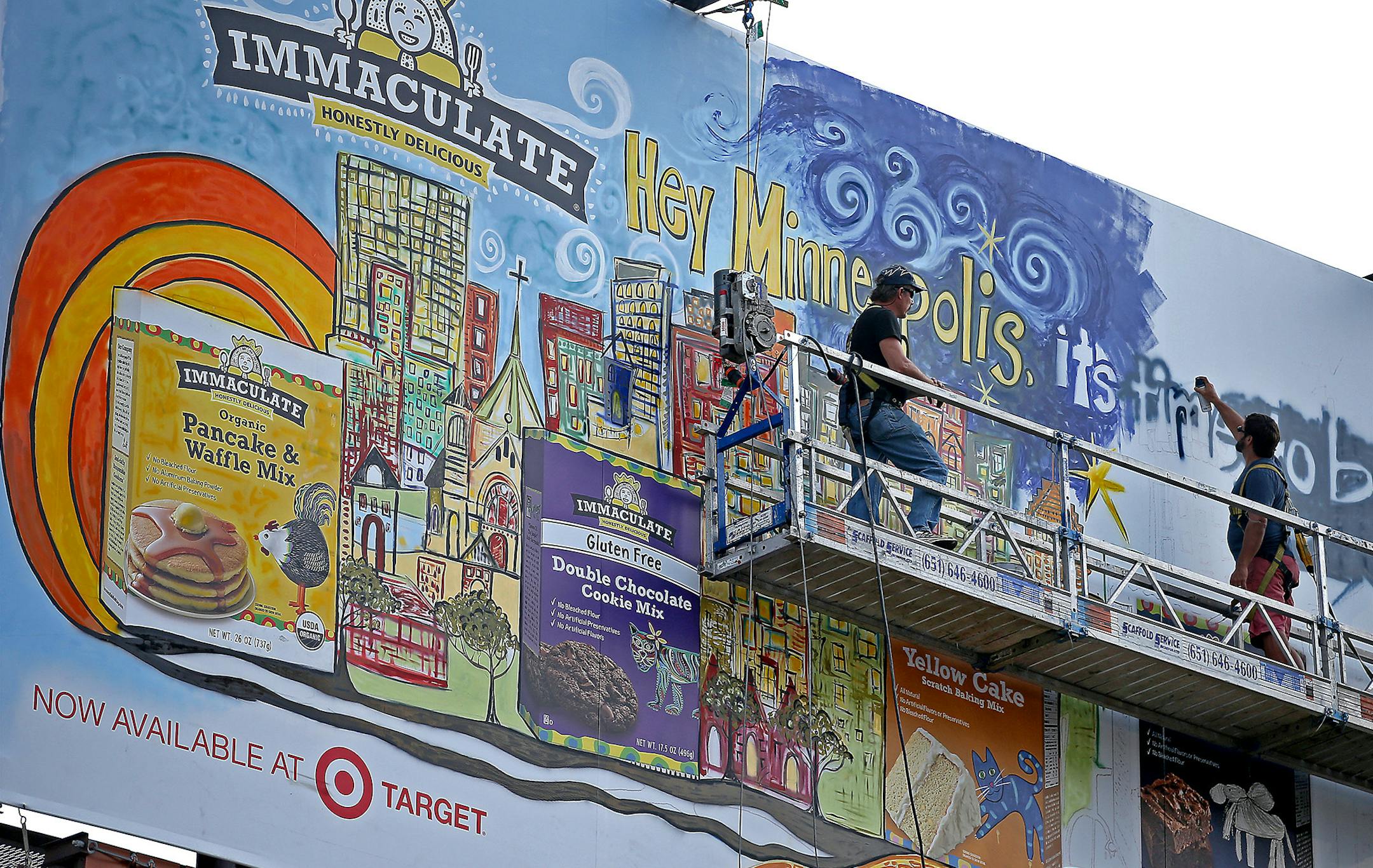 Mixed-media artist Andy Saczynski worked on a billboard in downtown Minneapolis, Thursday, August 7, 2014. Saczynski is painting the billboard 60-feet above 930 Hennepin (former National Camera building) to celebrate Immaculate Baking Company's new line of scratch baking mixes and ingredients. He specializes in assemblage art and works primarily in acrylic and found objects as well as recycled and reclaimed items. ] (ELIZABETH FLORES/STAR TRIBUNE) ELIZABETH FLORES • eflores@startribune.co