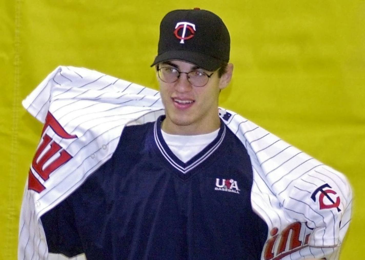 Joe Mauer puts on a Twins jersey during a news conference at Cretin-Derham Hall High School after he was the first player chosen in the 2001 MLB draft.