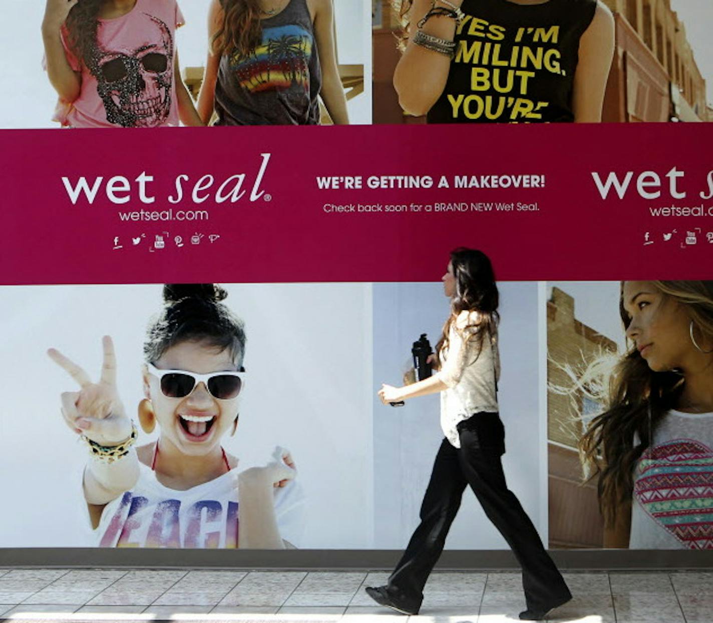 FILE - In this July 2, 2013 file photo, Shianne Penoli walks past the future location of Wet Seal at the Mt. Shasta Mall in Redding, Calif. Wet Seal is closing 338 of its stores, resulting in nearly 3,700 full and part-time workers losing their jobs. The retailer said that it decided to proceed with the store closures after looking at its overall financial condition and wasn&#xed;t able to negotiate meaningful concessions from landlords. The closures are effective Wednesday, Jan. 7, 2015. (AP Ph