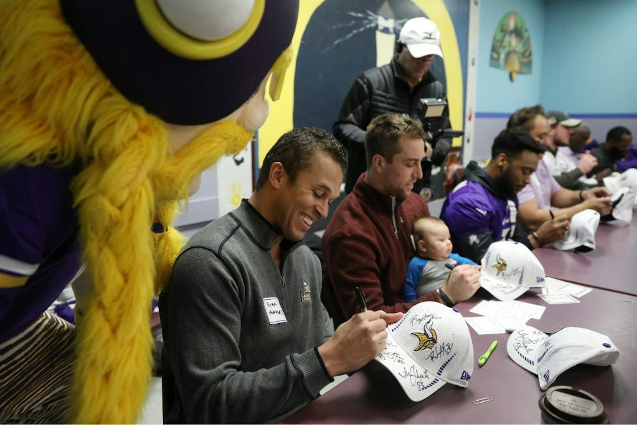 Former Minnesota Vikings wide receiver Ryan Hoag laughed as Viktor the Viking stood over his shoulder while signing autographs Tuesday.