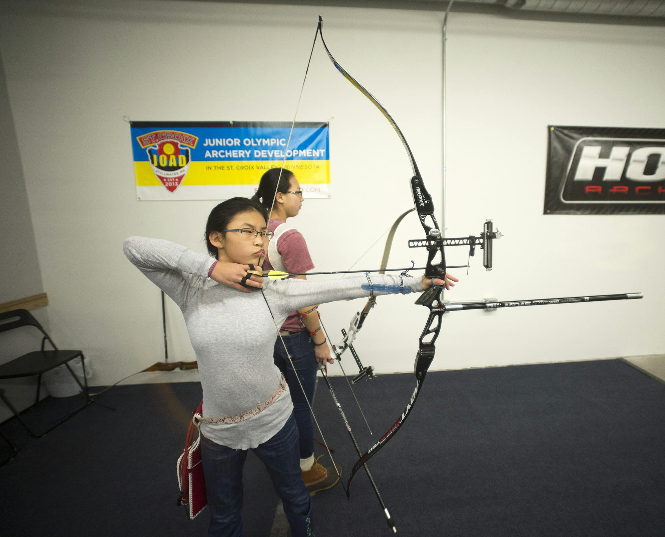 Elisabeth Kleinke, 12, left, sets up a shot while practicing archery on Tuesday night at the Minnesota NorthStar Archery Club in Woodbury. ] (Aaron Lavinsky | StarTribune) Diane Kleinke and her family along with other archers practice shooting at the Minnesota NorthStar Archery Club in Woodbury. They were photographed Tuesday, Feb. 24, 2015.