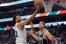 The Wolves' Karl Anthony Towns puts up a shot at the rim against the Mavericks' Dwight Powell during the second quarter Sunday night in Dallas.