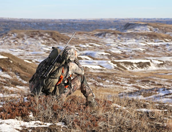 Peering through binoculars, Trevor Anderson joined his dad, Dennis, to hike into the vast badlands regioin of eastern Montana seeking mule deer.