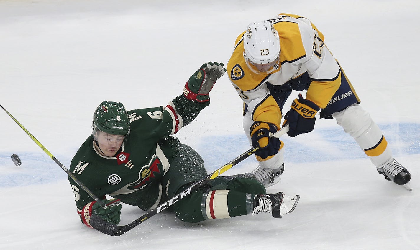 Minnesota Wild's Ryan Donato loses control of the puck after colliding with Nashville Predators' Rocco Grimaldi during the third period of an NHL hockey game Sunday, March 3, 2019, in St. Paul, Minn. The Predators won 3-2 in a shootout. (AP Photo/Stacy Bengs)