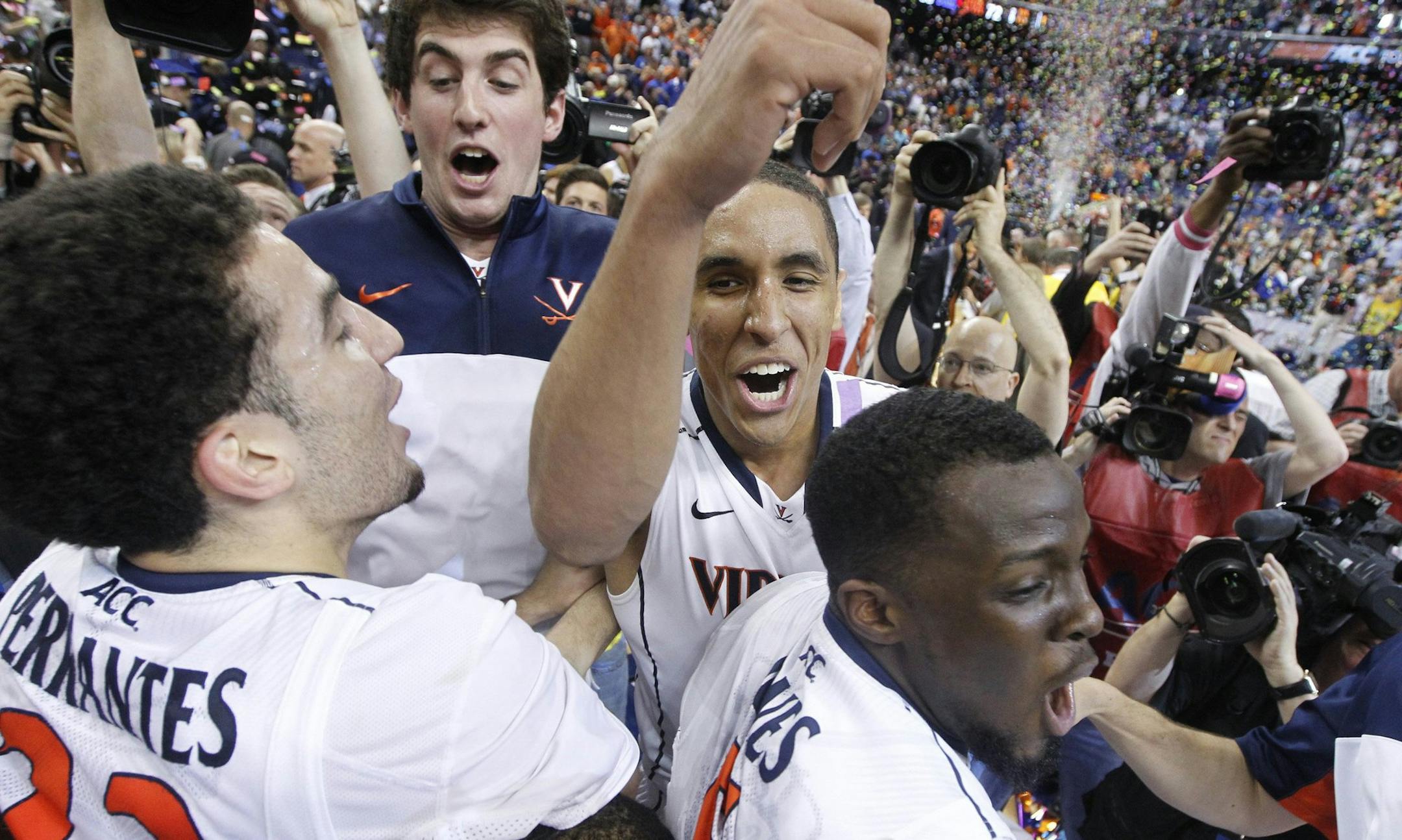 Virginia's London Perrantes (23), left, Malcolm Brogdon (15), center, and Teven Jones (5) celebrate at Greensboro Coliseum in Greensboro, N.C., on Sunday, March 16, 2014. The Virginia Cavaliers defeated the Duke Blue Devils, 72-63, in the men's Atlantic Coast Conference Tournament. (Ethan Hyman/Raleigh News & Observer/MCT)
