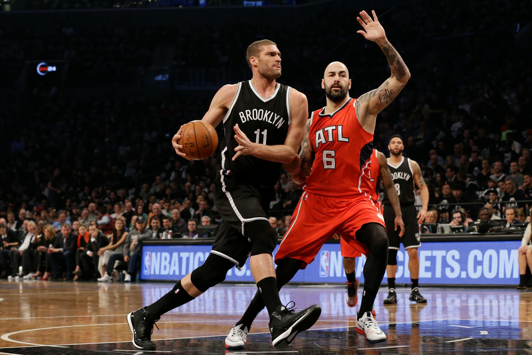 Brooklyn Nets center Brook Lopez (11) drives to the basket against Atlanta Hawks forward Pero Antic during the first half in Game 3 of a first-round NBA basketball playoff series, Saturday, April 25, 2015, at New York. (AP Photo/Mary Altaffer)