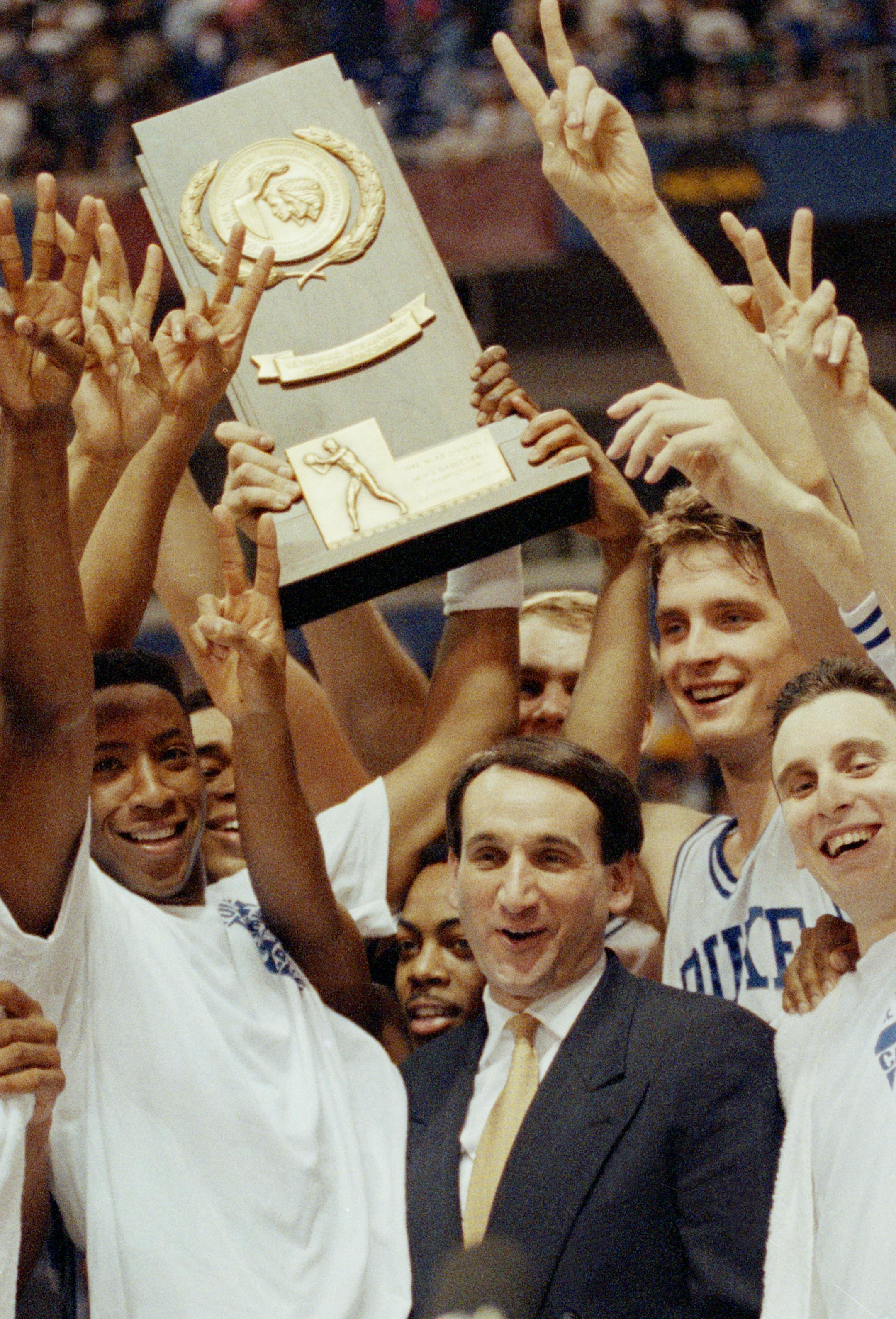 Coach Mike Krzyzewski and his Duke team celebrate in Minneapolis, April 7, 1992, after receiving their championship trophy. Duke beat Michigan 71-51 to become the first team to repeat as national champions since 1973. (AP Photo/Jim Mone) ORG XMIT: APHS462766
