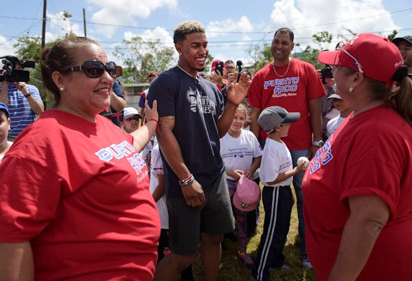 School teachers Norma Torres, right, and Evelyn Hernandez, greet Cleveland Indians All-Star shortstop Francisco Lindor, how visited his former grammar