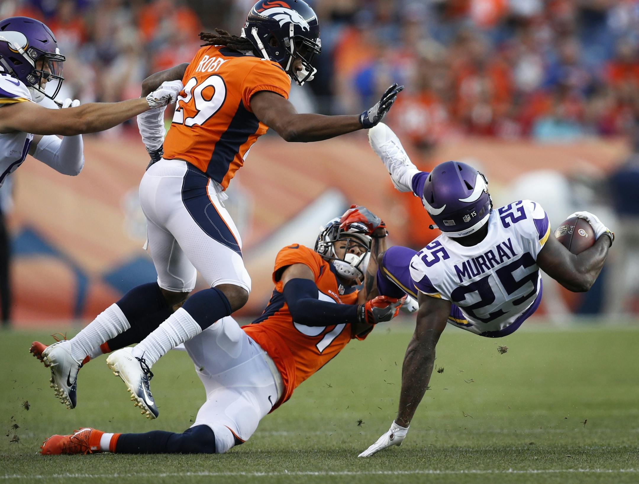 Minnesota Vikings running back Latavius Murray (25) was upend by Denver Broncos defensive back Justin Simmons (31) after picking up 21 yards Saturday August 11, 2018 at Broncos Stadium at Mile High in Denver, CO.