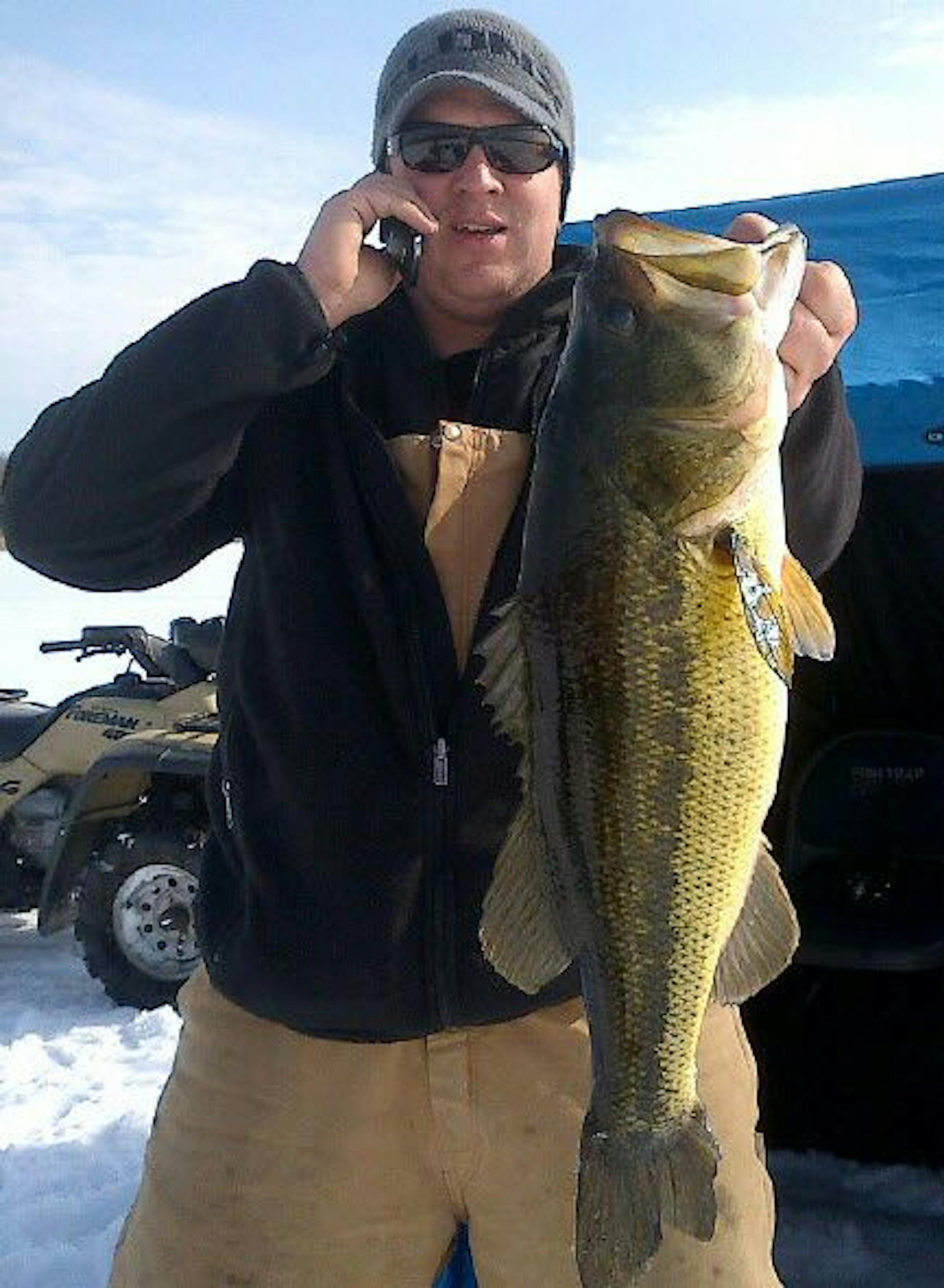 BIG BUCKETMOUTH -- Jon Sontag of Lakeville takes a call while showing off a monster largemouth bass he caught last week on a lake near Pelican Rapids in Ottertail County. "We had never fished the lake before, and set up hoping for some crappies and northerns,'' said friend Steve Zweber of Farmington. The group of four caught six northerns, a "nice batch of sunfish,'' some crappies and several bass, including this dandy, which they estimated at about 5.5 pounds. They released it.