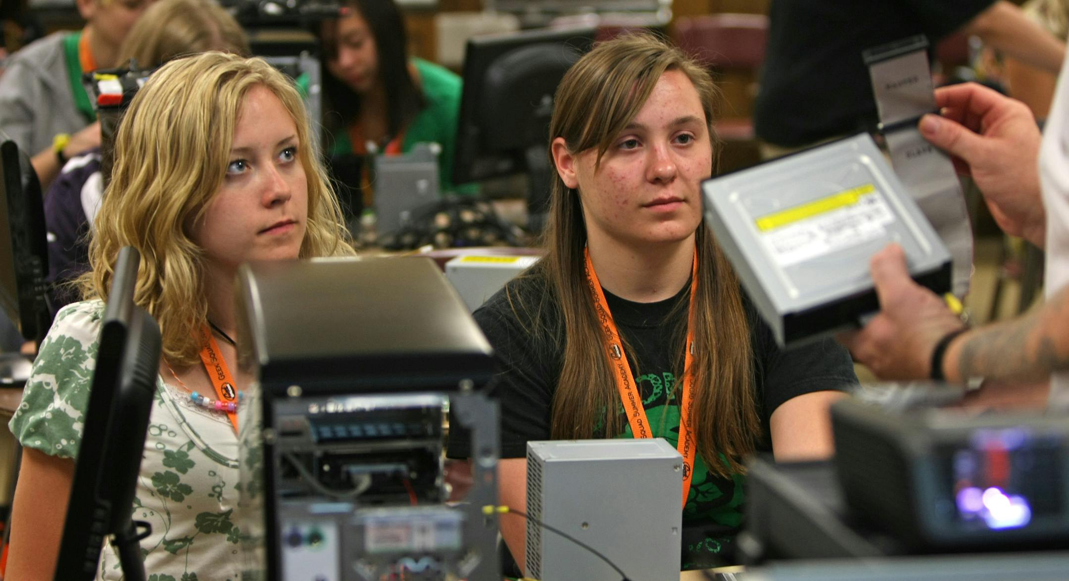 (left to right) Callie Turner and Kelsey Piepkorn listened as Geek Squad Double Agent #194 Ed Dean explained the different types of hard drives during computer assembly class at the Best Buy Geek Squad Summer Academy for Girls at Mound Westonka High School. The Mound location is one of twelve sites nationwide for the three day camp, which hopes to get girls involved in all types of technology. Building computers, launching web sites, video gaming and creating multi-media projects are just afew o