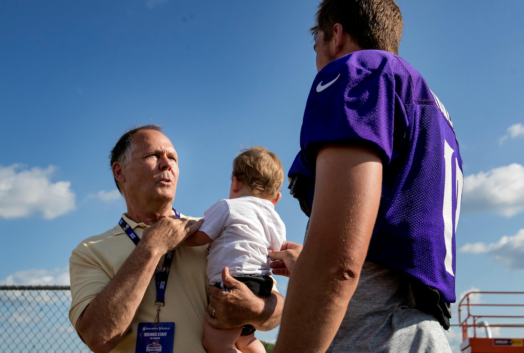 Minnesota Vikings team Champlain Tom Lamphere spoke to receiver Adam Thielen as he held Thielen's son Asher at the end of the afternoon practice.