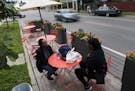 Inez Howard, left, talks with her daughter Shanay Ponder at the new parklet seating outside of Twin Cities Coffee and Deli on Chicago Ave. on Wednesda