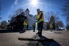 Workers with the city of St. Paul patch potholes along 6th Street on April 5.
