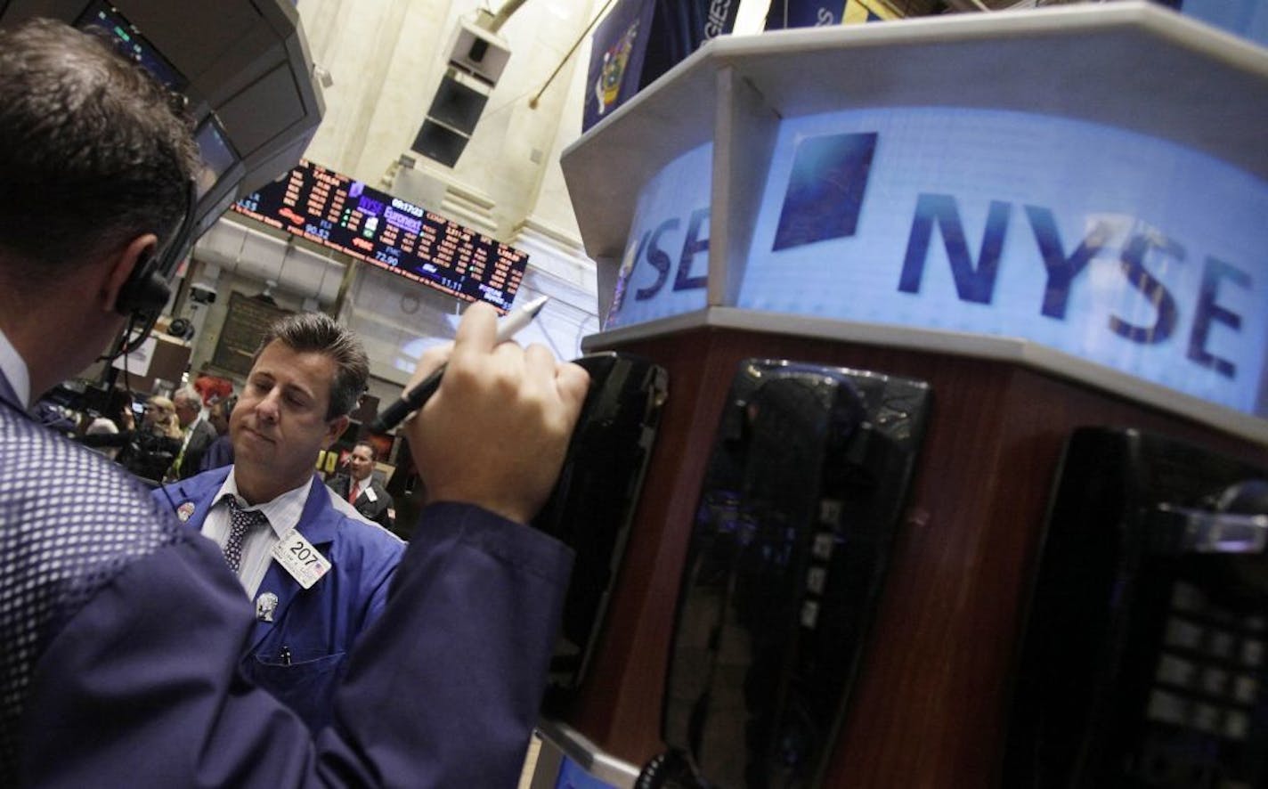 In this Aug. 18, 2011 photo, trader William Sachs, right, talks with a fellow trader on the floor of the New York Stock Exchange. Global stock markets slumped Friday, Sept. 2, 2011, ahead of the release of U.S. employment figures, which will be scrutinized for clues about the state of the world's largest economy.