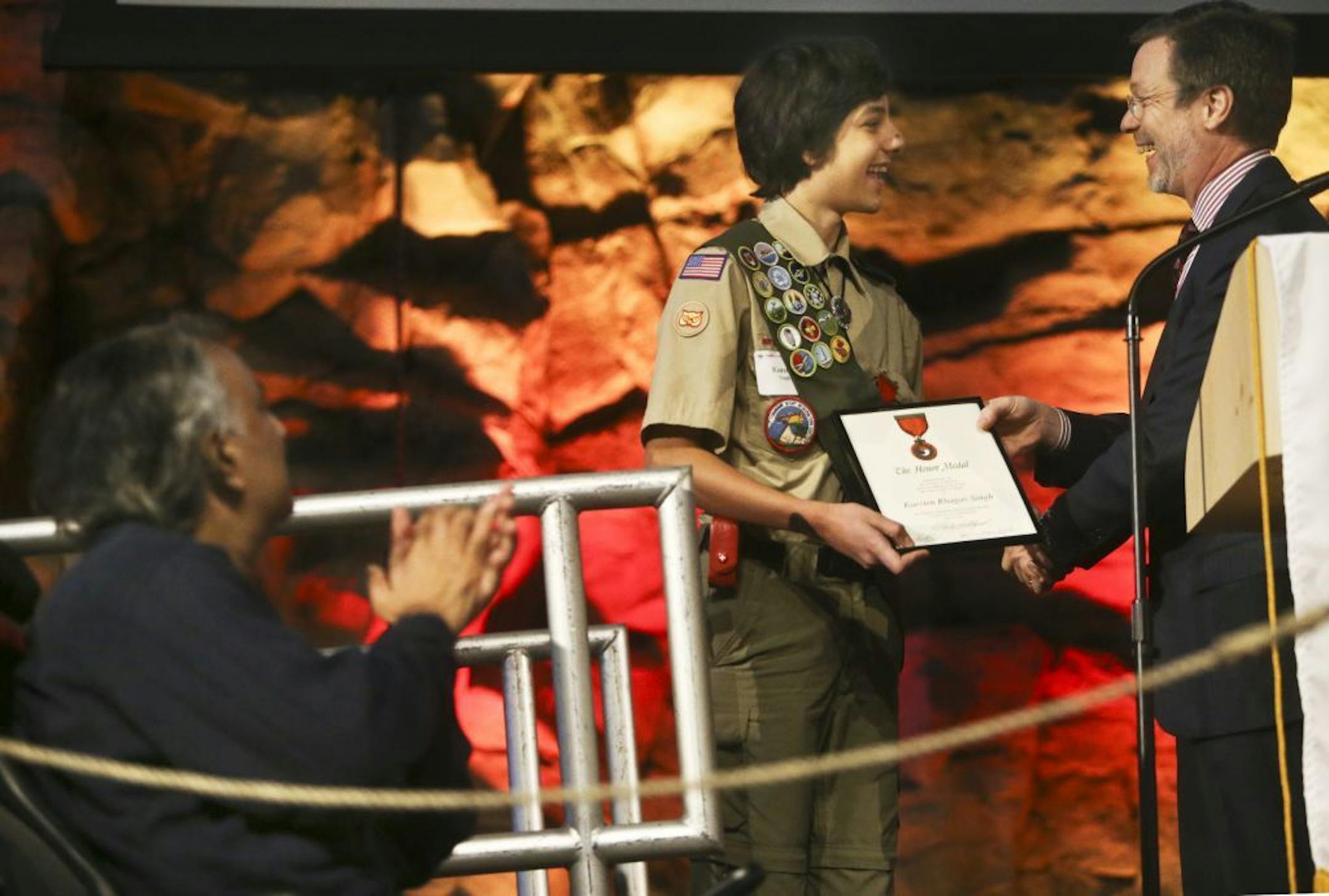As his father Raghav Singh looks on, left, Northfield Boy Scout Karsten Singh,14, was awarded the Honor Medal by Brian Bulloch, Northern Star Council commissioner, during a ceremony at the Boy Scouts Base Camp Thursday, Dec. 12, 2013, at Fort Snelling, MN.
