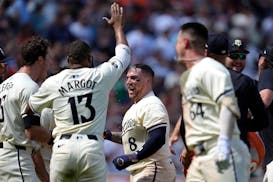 The Twins' Christian Vázquez (8) rejoices with teammates while crossing home plate after he hit a walk-off homer in the ninth inning Sunday.
