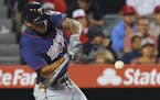 Minnesota Twins' Byron Buxton hits a solo home run as Los Angeles Angels catcher Carlos Perez watches during the sixth inning of a baseball game Monda