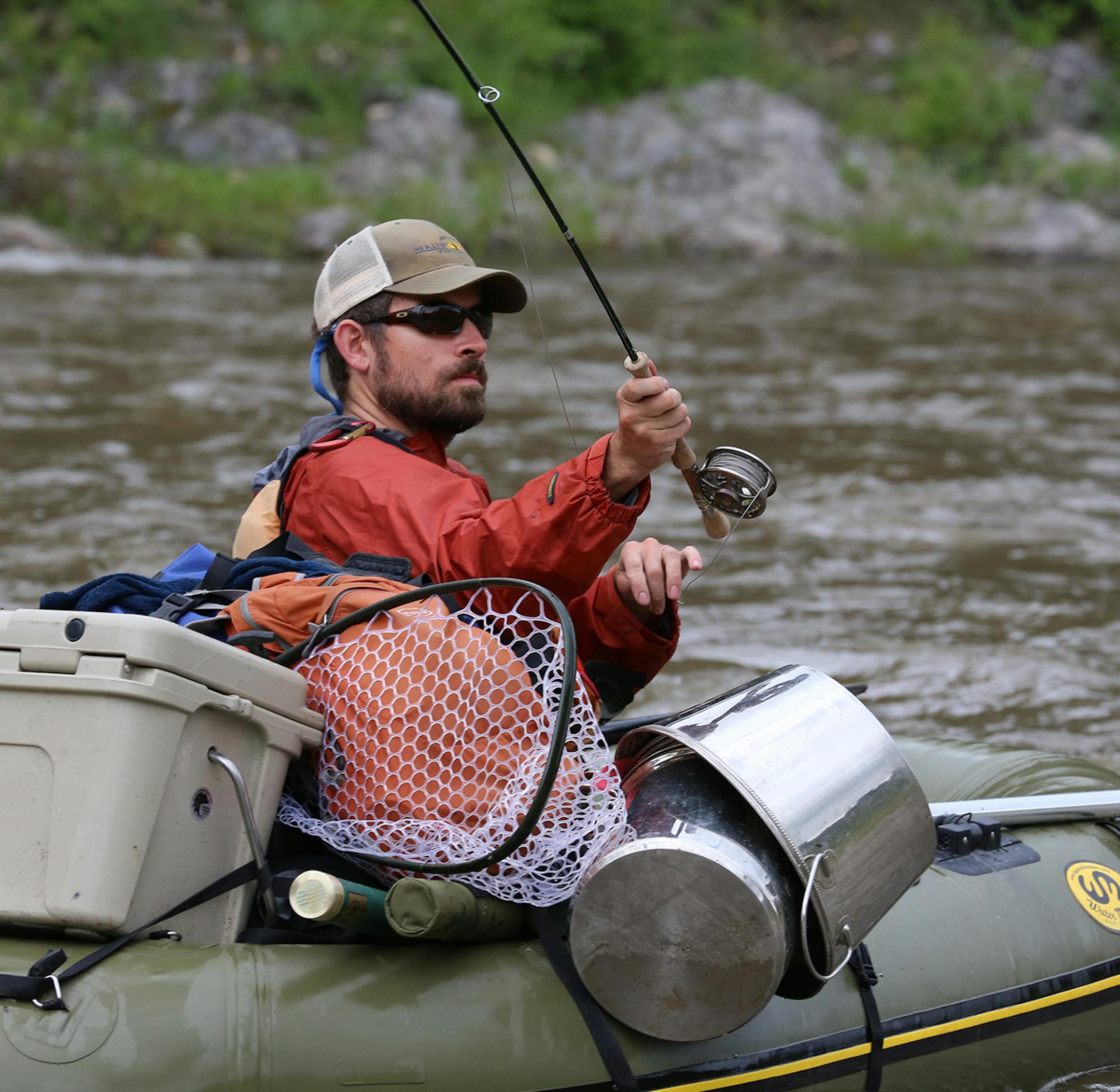 An angler in a one-man raft casts to a likely looking trout haunt while floating Montana's Smith River.