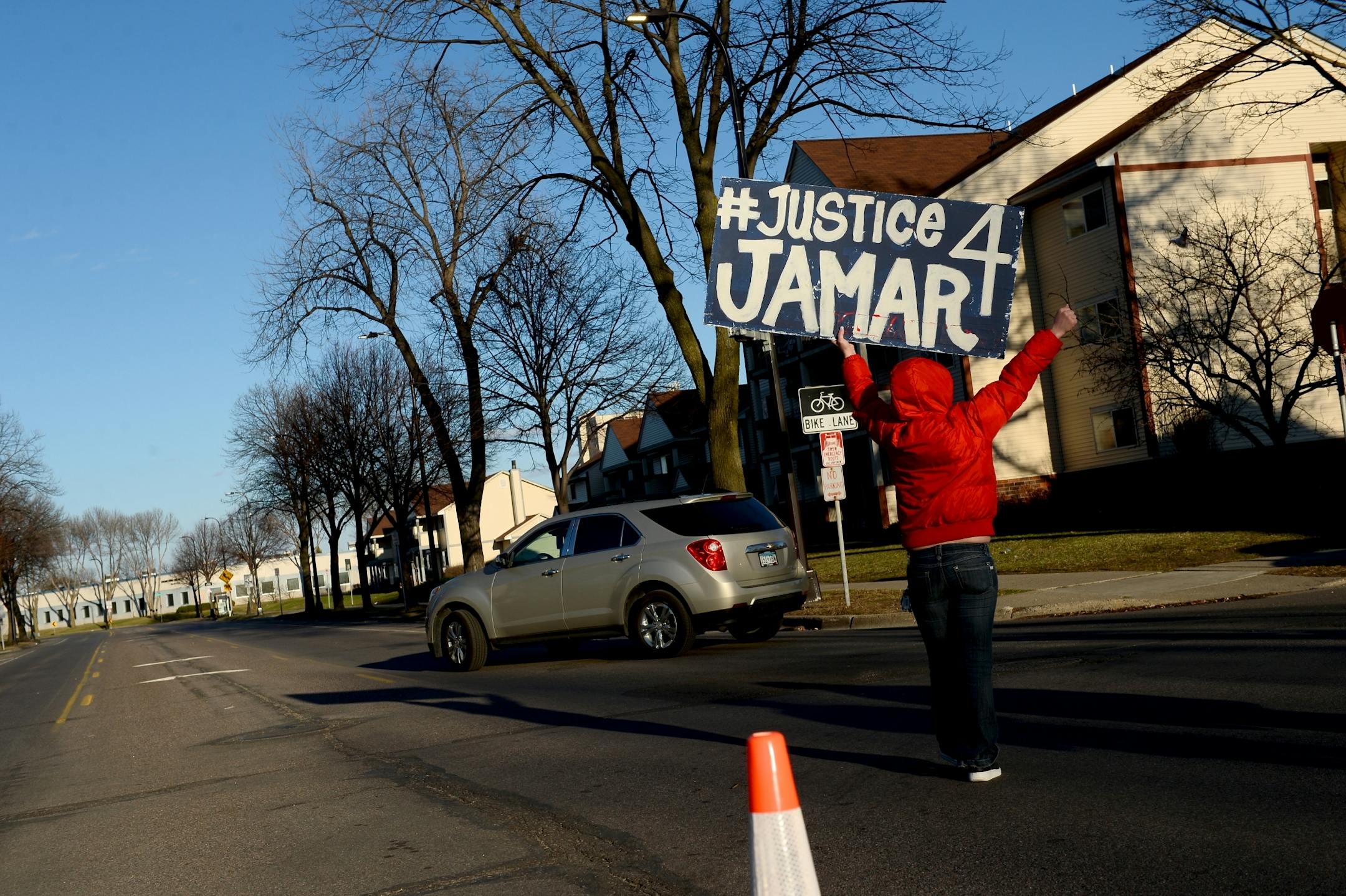A protestor waved a "Justice 4 Jamar" banner at traffic turning onto Plymouth Avenue Friday afternoon.