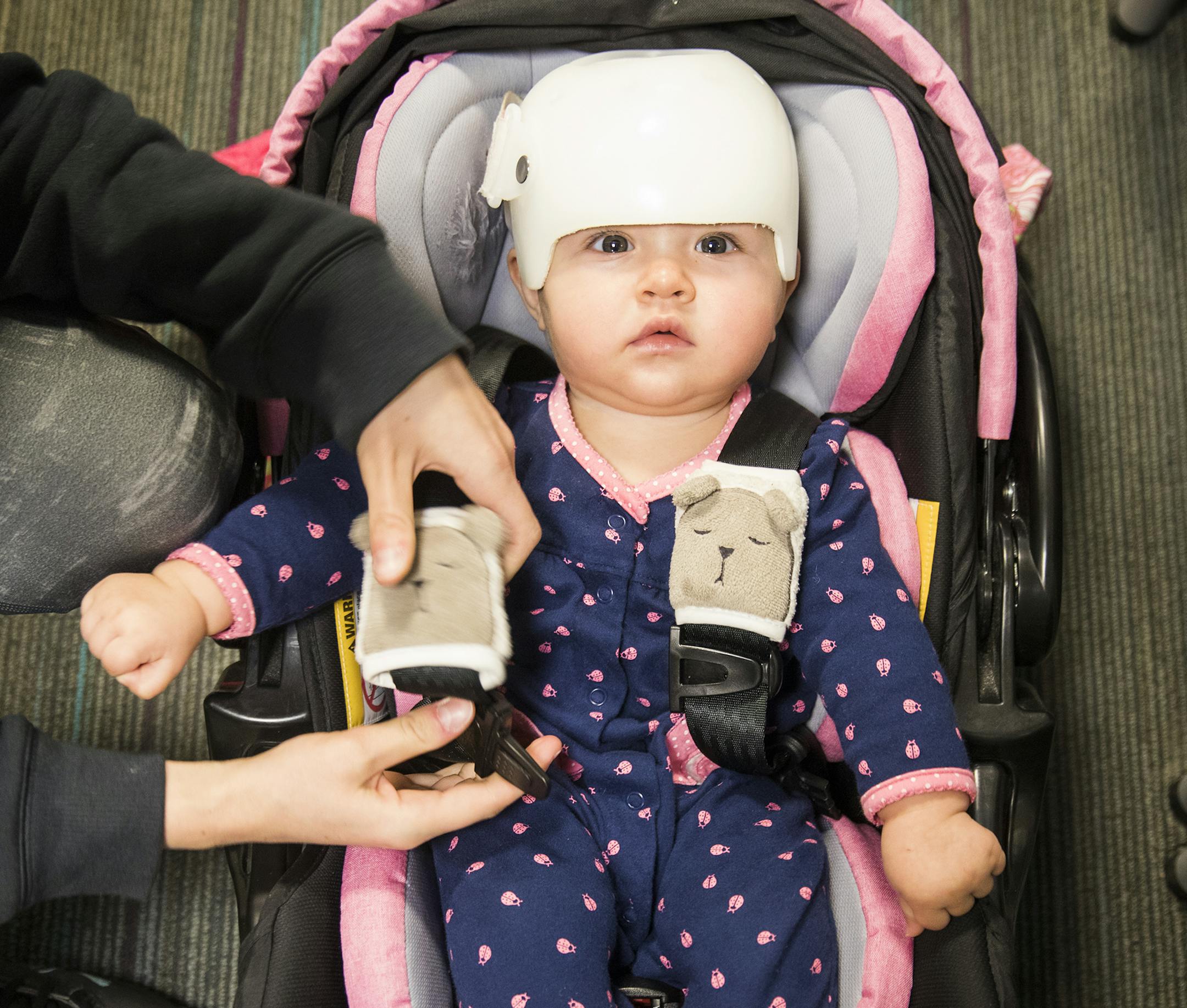 Eight-month-old Evelyn Shenefield wears her cranial cap after an adjustment appointment with her mother Katie Jensen of Oakdale. ] LEILA NAVIDI &#xef; leila.navidi@startribune.com BACKGROUND INFORMATION: Cranial cap appointments at Gillette Children's Speciality Healthcare in St. Paul on Tuesday, May 1, 2018.