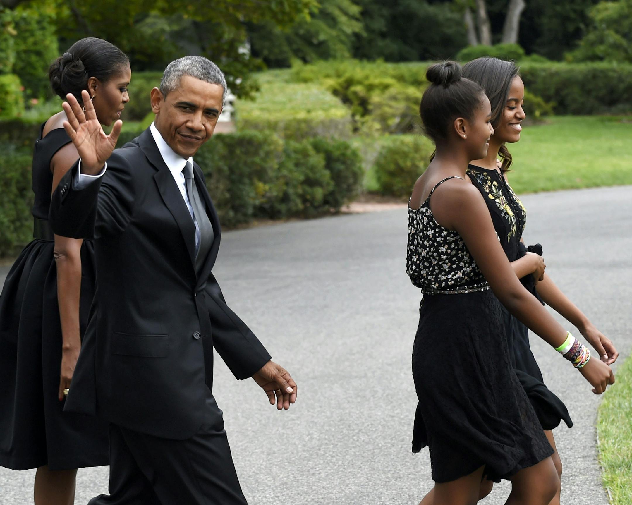 FILE - In this Aug. 30, 2014 file photo, President Barack Obama, accompanied by first lady Michelle Obama, waves as they follow their daughters Sasha, second from right, and Malia out of the White House in Washington. President Barack Obama is headed to New York for a rare father-daughter weekend in the city. He&#x2019;ll also collect some cash for Democrats while he&#x2019;s there. (AP Photo/Susan Walsh, File)