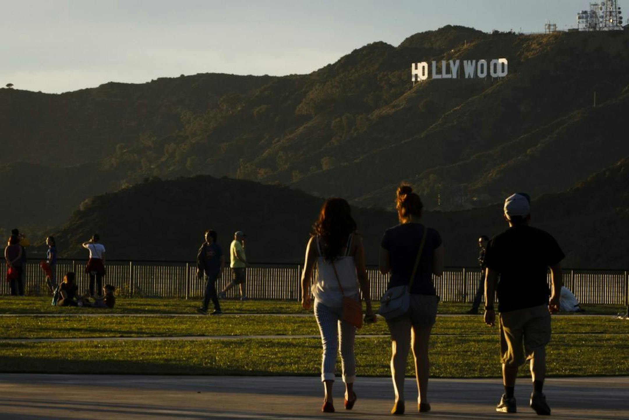 Tourists walk past the Hollywood Sign in Los Angeles on March 14, 2013. MUST CREDIT: Bloomberg photo by Patrick T. Fallon.