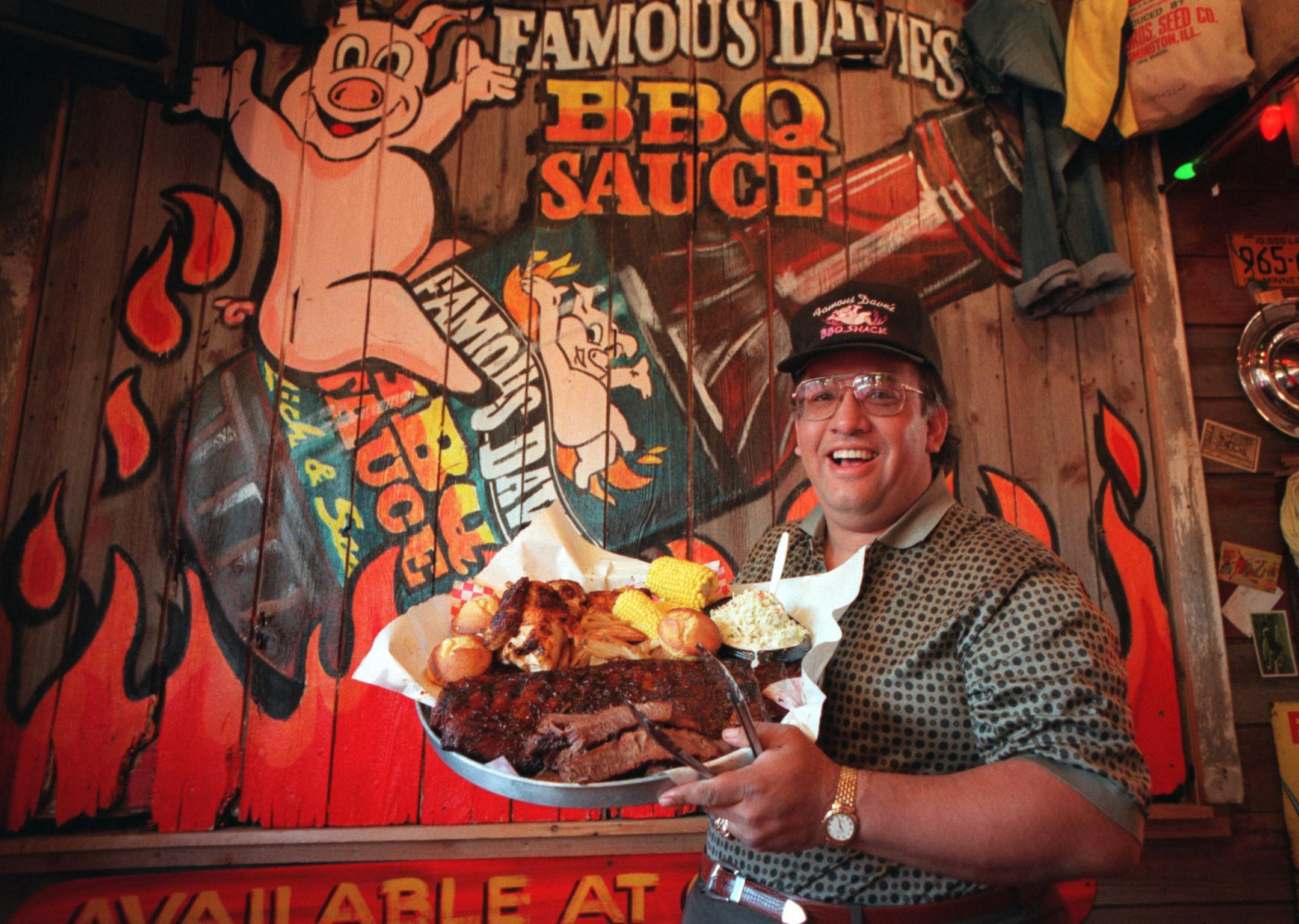 "Famous" Dave Anderson with his All-American BBQ Feast, which is served (if to stay) on a garbage can lid. For $45.95 you get a full slab of ribs, a whole chicken, 1/2 lb beef brisket, coleslaw, shack fries, wilbur beans, and four corn bread muffins. Dave was photographed at Famous Dave's BBQ Shack at 43rd and Upton in Linden Hills. There's another location in Roseville, and two more on the way.