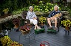 Christine Scotillo and Doug Peine, with their dog Gracie, relax on a round deck built in the middle of their back-yard pond. Their St. Paul garden is 