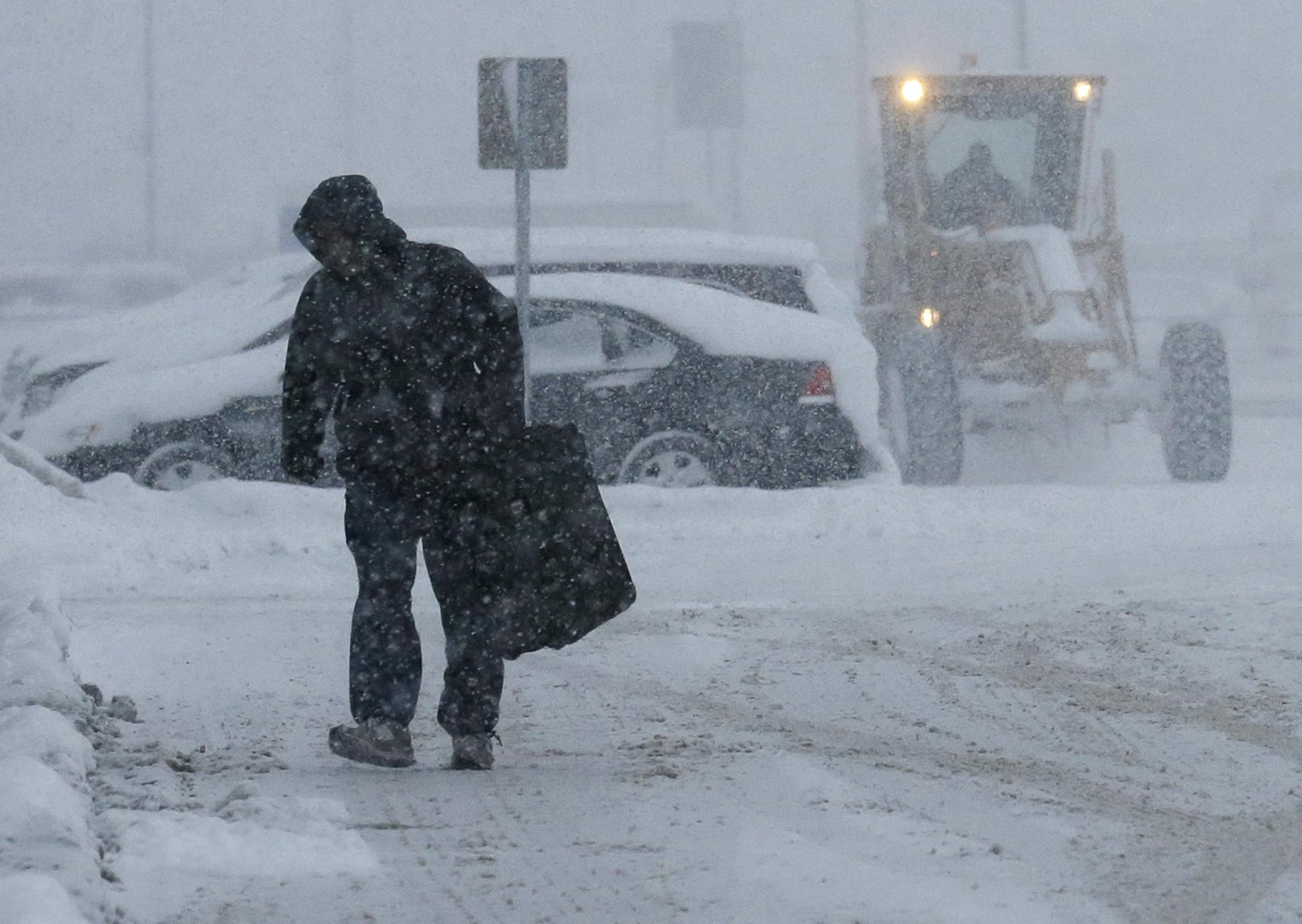 A traveler walks in the economic parking lot at O'Hare International Airport in Chicago, Thursday, Jan. 2, 2014. Another one to three inches of snow could fall across the Chicago metro area Thursday with even more falling in the southern part of the region, according to the National Weather Service.