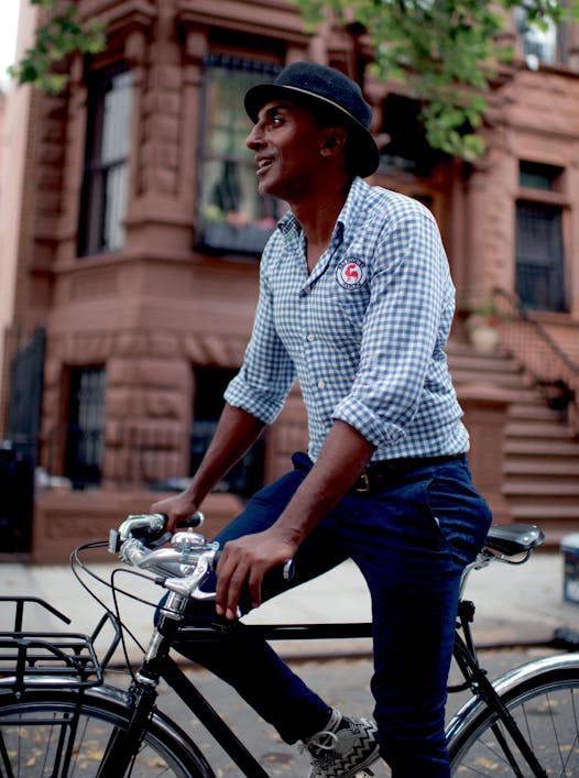 Marcus Samuelsson rides a bike in Harlem, where his restaurant Red Rooster is located.