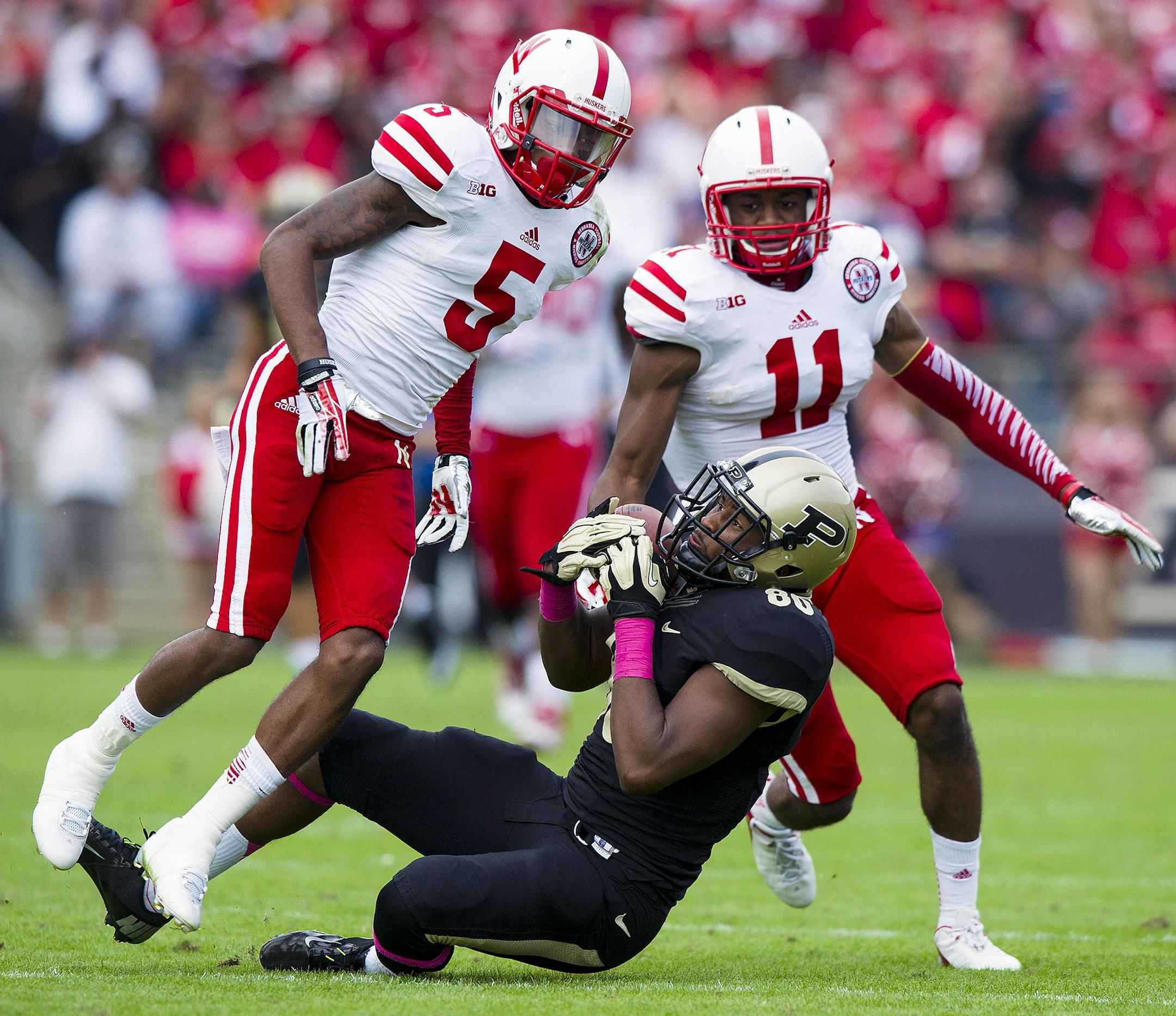 Purdue's DeAngelo Yancey (80) comes down with a pass reception despite the coverage from Nebraska's Josh Mitchell (5) and Andrew Green (11) during the second half of an NCAA college football game, Saturday, Oct. 12, 2013, in West Lafayette, Ind. Nebraska defeated Purdue 44-7. (AP Photo/Doug McSchooler)
