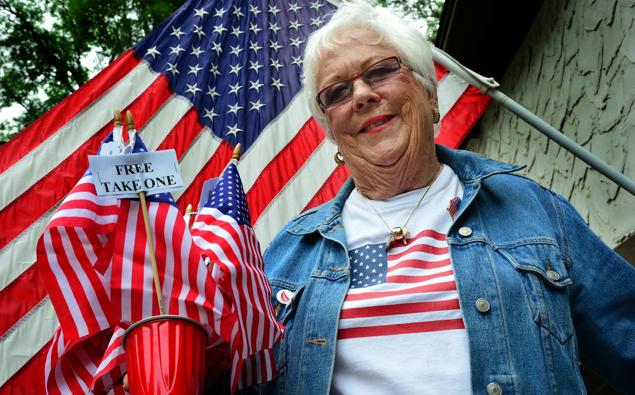 Martie McGlasson of Tonka Bay leaves her house to go door-to-door fundraising for Lake Minnetonka's annual Fourth of July celebration. Carrying a bucket of flags, McGlasson is going around asking residents to help support the largely free event that is mostly supported by donations. When she can't speak directly to residents she will leave a flag with donation information on a tag. ]Richard.Sennott@startribune.com Richard Sennott/Star Tribune Tonka Bay Minn.Wednesday 6/25/2014) ** (cq) ORG XMIT: