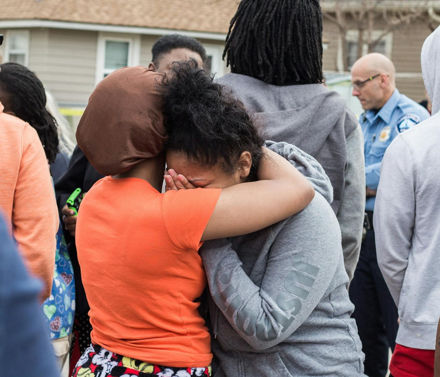 Teonna Johnson-Fraakan, blook cousin of the victim is comfoted by Hani Jeylani near the scene of the shooting, Friday afternoon.] Elizabeth Brumley special to the Star Tribune *