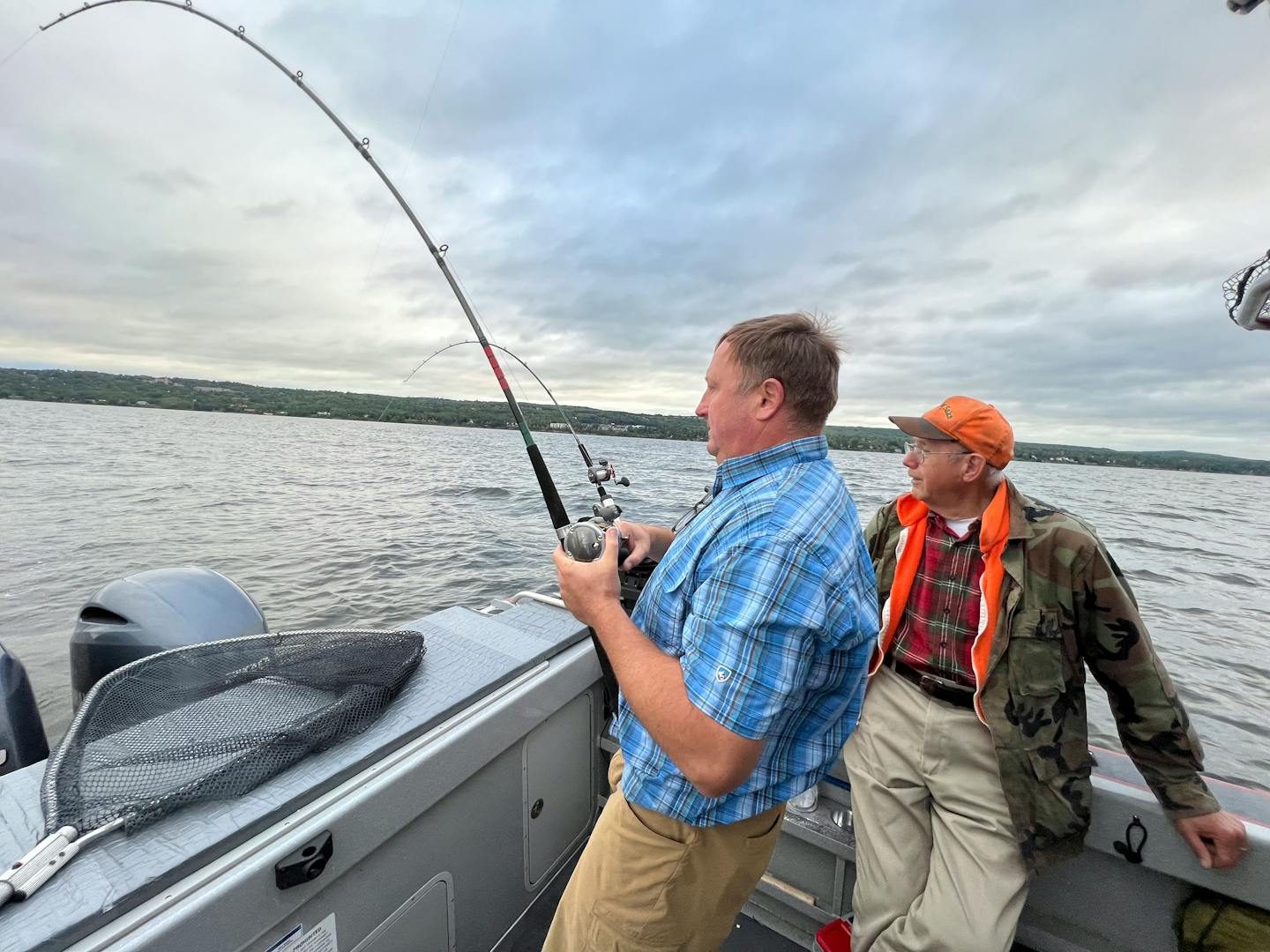 Mark Strelnieks of the Twin Cities fights a lake trout on Lake Superior while Pete Harris of Grand Marais looks on.