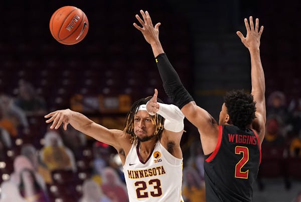 Minnesota forward Brandon Johnson (23) passed the ball off as Maryland guard Aaron Wiggins (2) defended in the first half.