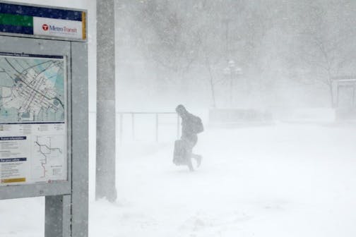 A traveler fought through the snow and ice to get to the Metro Government Center Plaza station as the snow picked up in downtown Minneapolis.