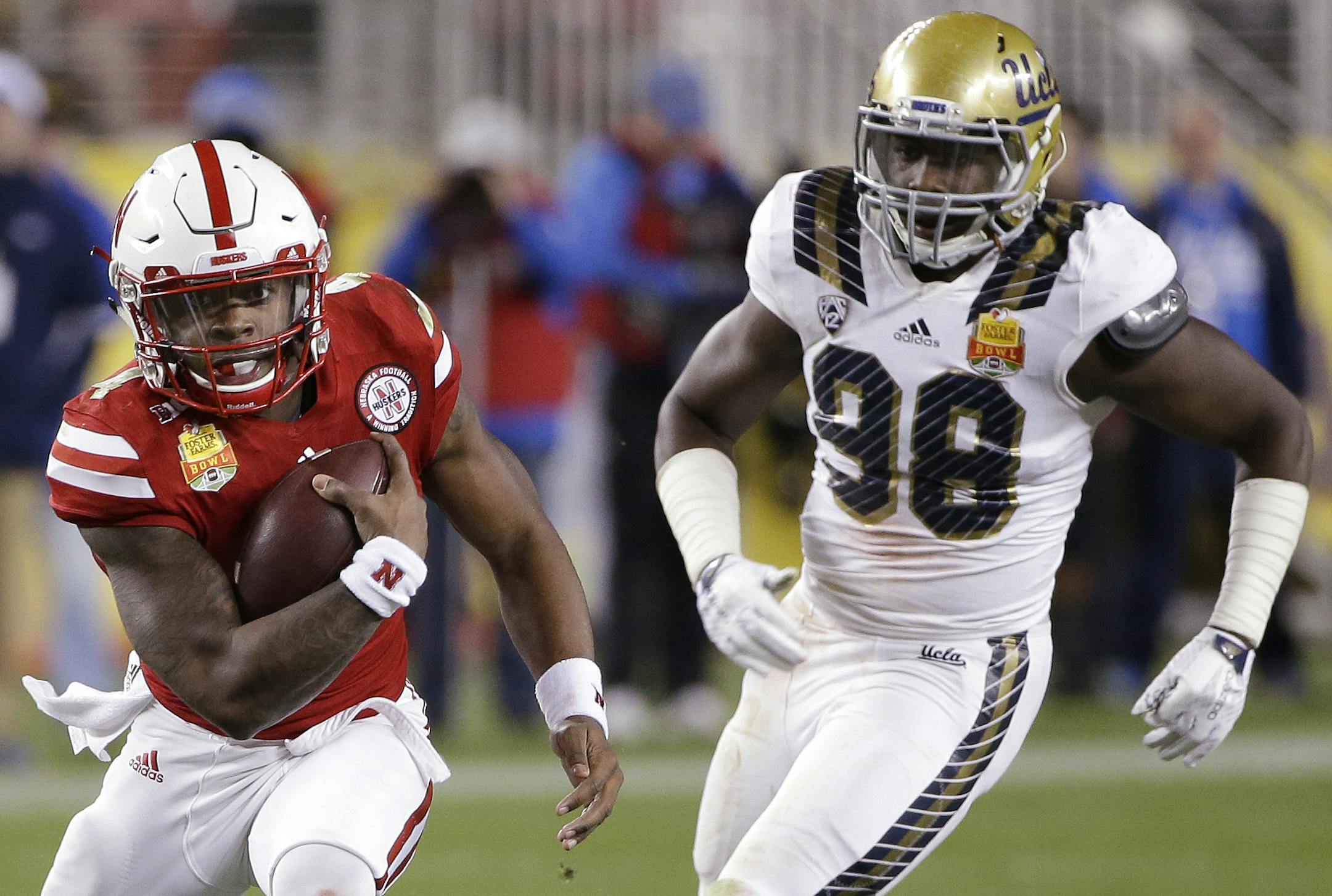 Nebraska quarterback Tommy Armstrong Jr., left, runs past UCLA defensive lineman Takkarist McKinley (98) during the first half of the Foster Farms Bowl NCAA college football game Saturday, Dec. 26, 2015, in Santa Clara, Calif. (AP Photo/Marcio Jose Sanchez)