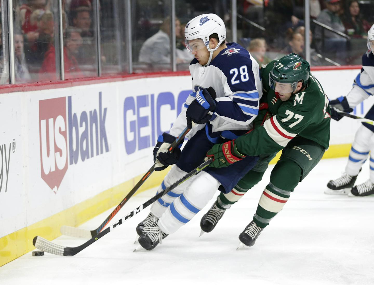 Winnipeg Jets forward Jack Roslovic (28) controls the puck in front of Minnesota Wild defenseman Brad Hunt (77) in the first period of an NHL hockey game Sunday, Sept. 29, 2019 in St. Paul, Minn. (AP Photo/Andy Clayton-King)