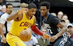 Kyrie Irving, left, watches the ball with Andrew Wiggins in the first quarter of an NBA basketball game, Friday, Jan. 8, 2016, in Minneapolis. (AP Pho